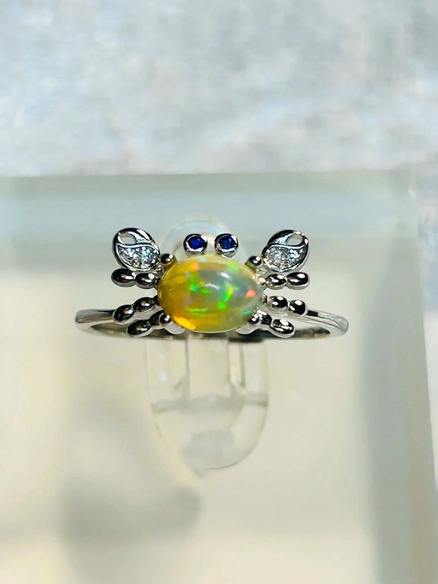 Celtic Dragon Jewellery sterling silver adjustable crab ring with rainbow opal, CZ pincers, and blue CZ eyes. Ocean-inspired.