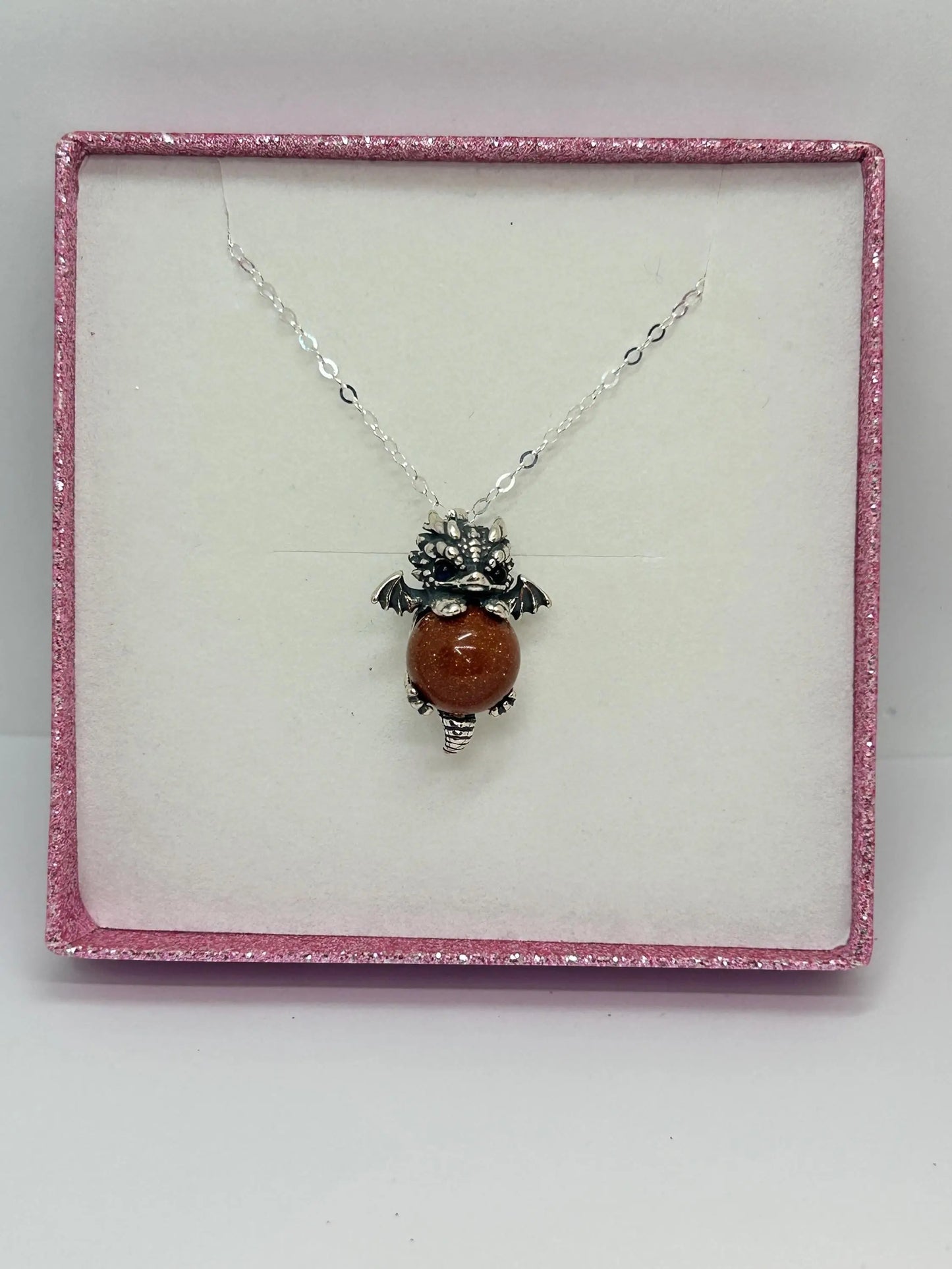 Celtic Dragon Jewellery sterling silver baby dragon pendant with red sandstone sphere and blue eyes, gift boxed.