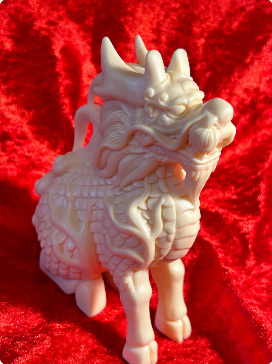 Front three-quarter view of a 5-inch cream-coloured Chinese dragon figurine made from ivory nut composite, featuring detailed horns, flowing whiskers, textured scales and an open mouth against red velvet.