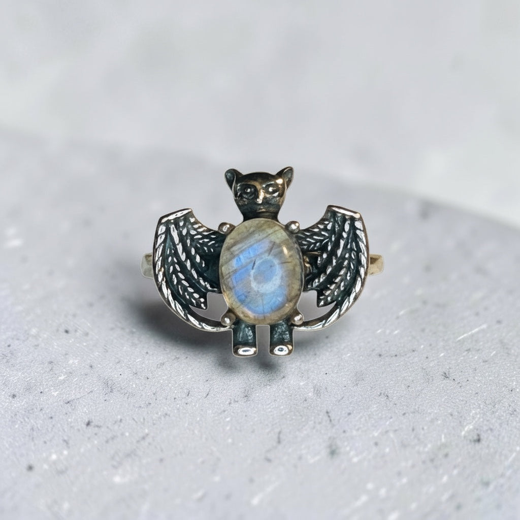 Celtic Dragon Jewellery silver bat ring with oval labradorite gemstone, featuring intricate wings and a blue flash. Adjustable.