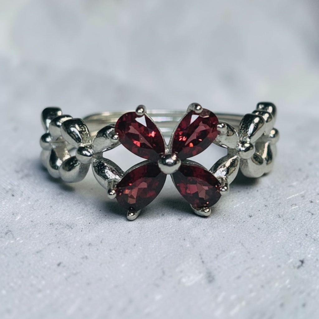 Celtic Dragon Jewellery adjustable 925 sterling silver ring with a flower cluster of deep red garnets and Celtic knot detailing.