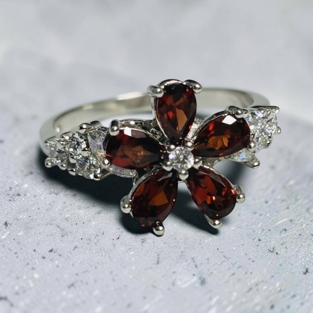 Celtic Dragon Jewellery adjustable silver spinner ring with garnet gemstone flower design and cz accents.