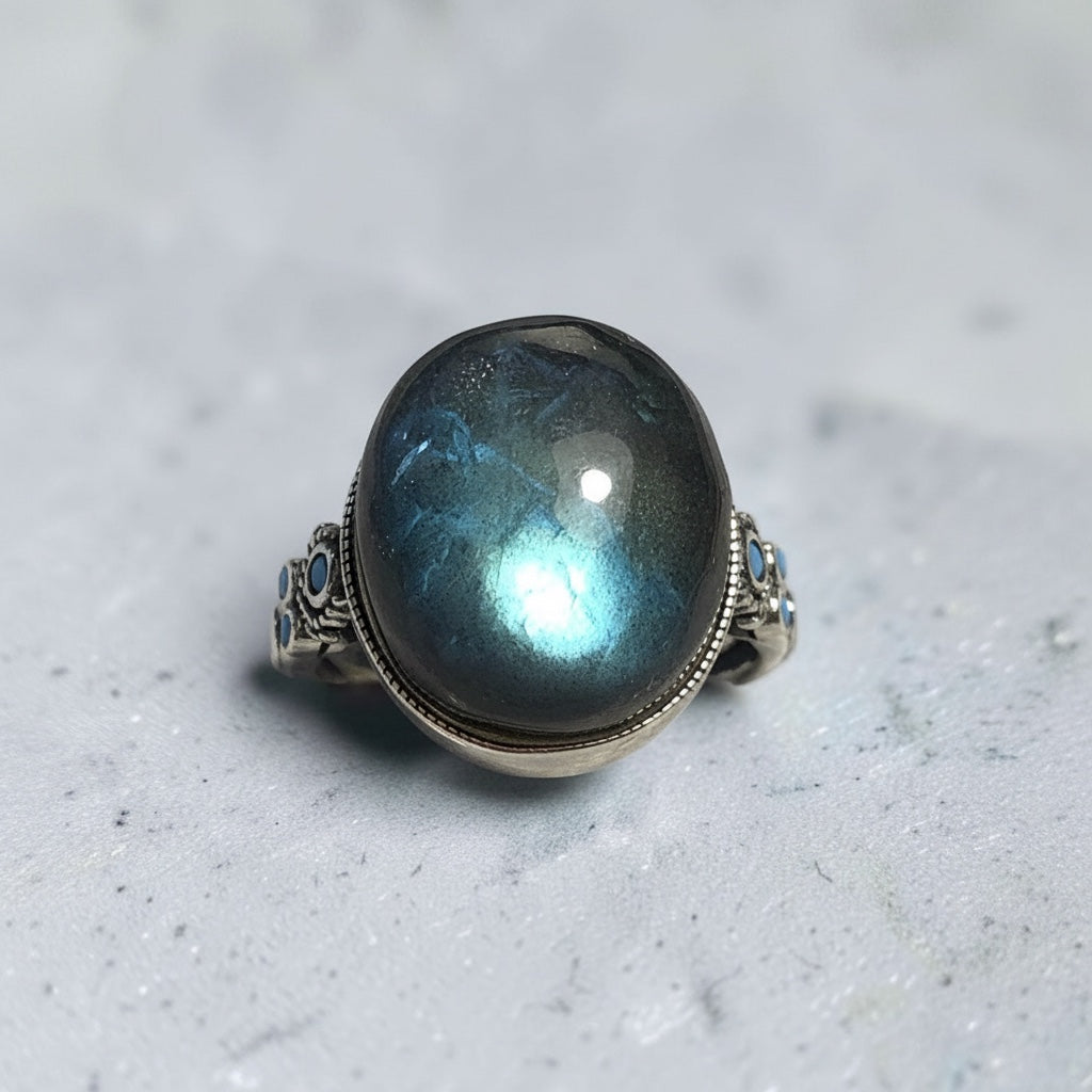 Celtic Dragon Jewellery adjustable 925 silver ring with a large round labradorite stone showing blue and gold flashes, and smaller blue stones on the band.
