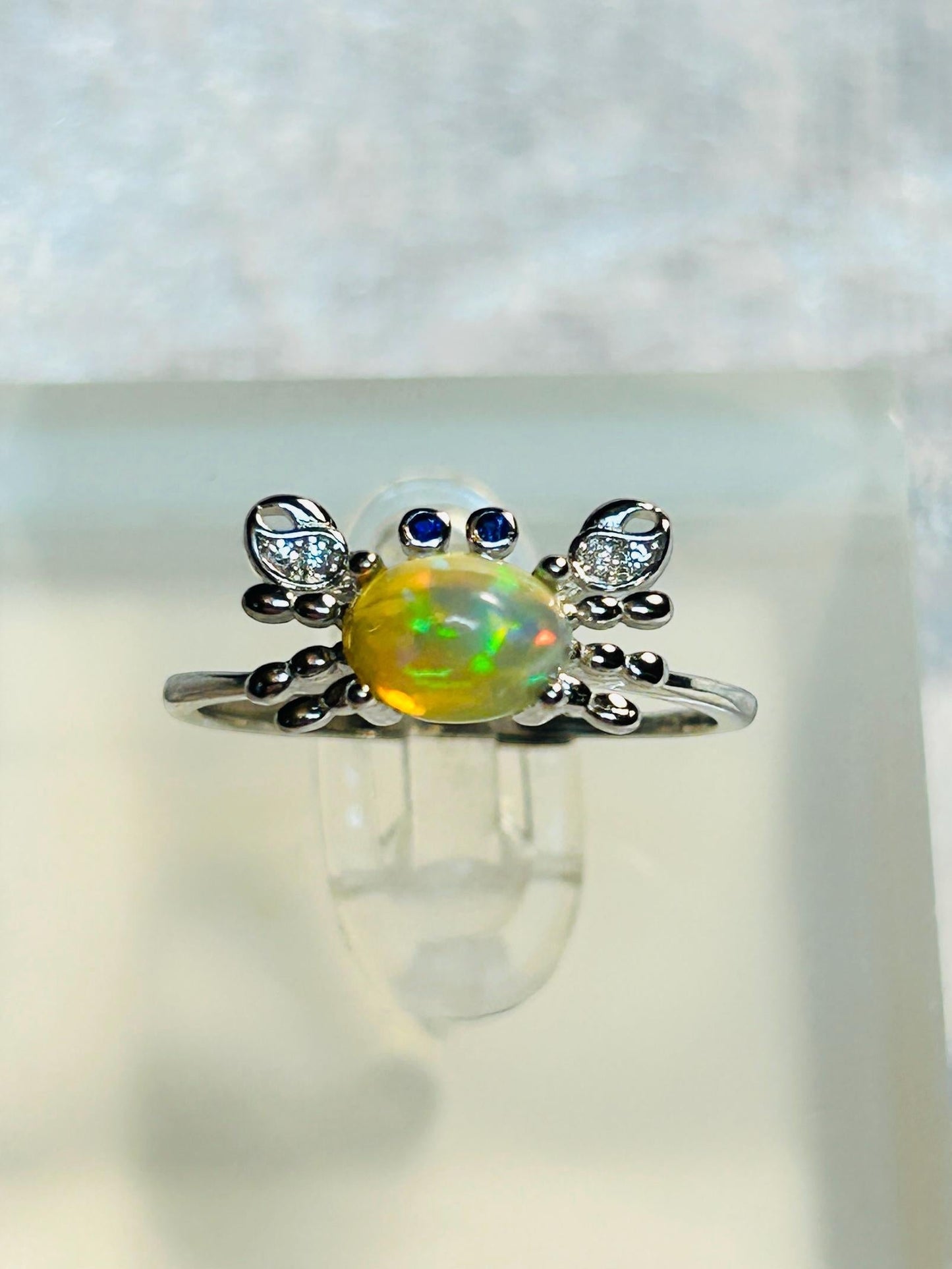 Celtic Dragon Jewellery sterling silver adjustable crab ring with rainbow opal, CZ pincers, and blue CZ eyes. Ocean-inspired.