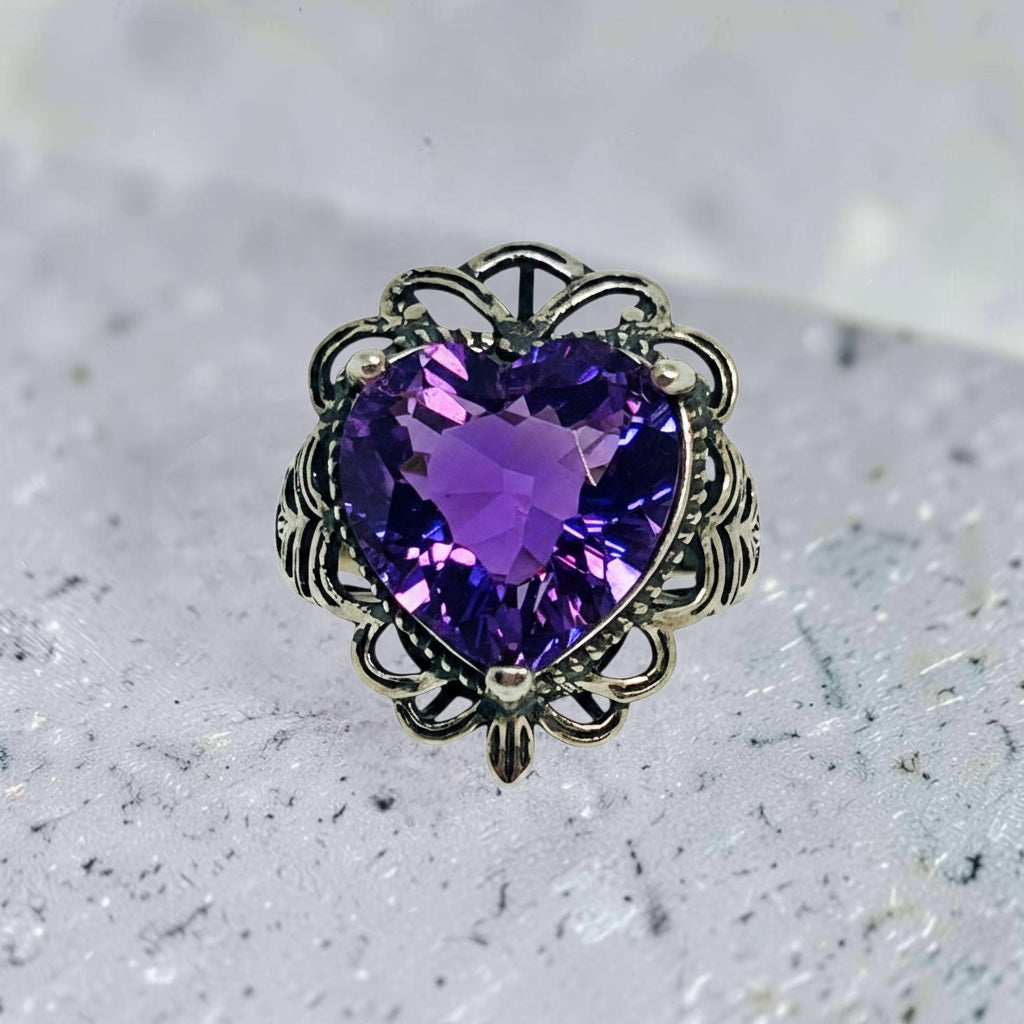 Celtic Dragon Jewellery sterling silver ring with a heart-shaped amethyst gemstone and ornate detailing. Adjustable size.