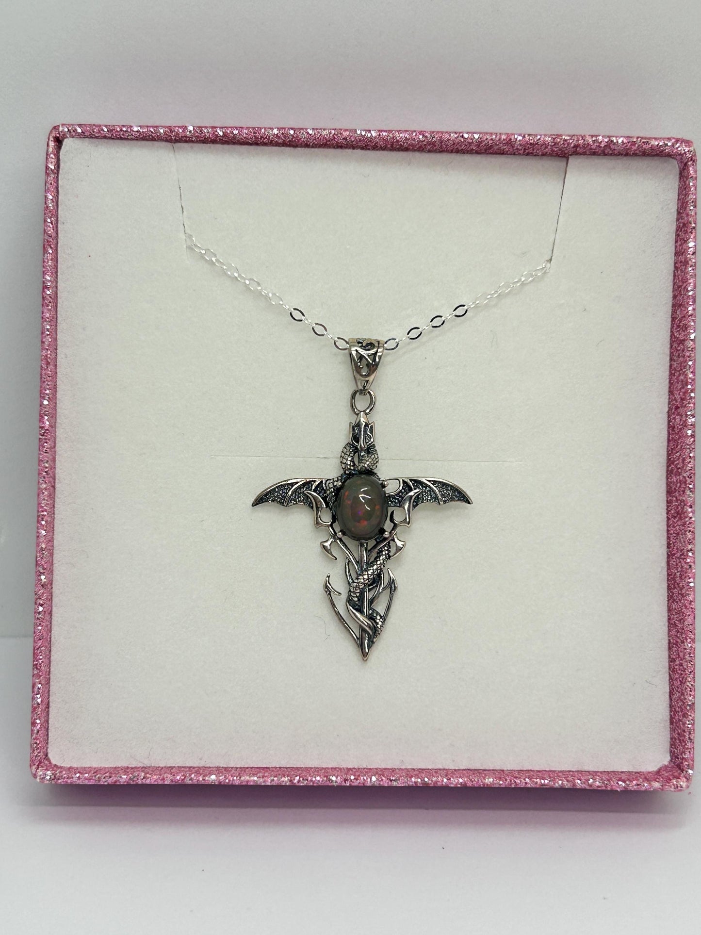 Celtic Dragon Jewellery sterling silver dragon cross pendant with black opal gemstone and intricate scales.