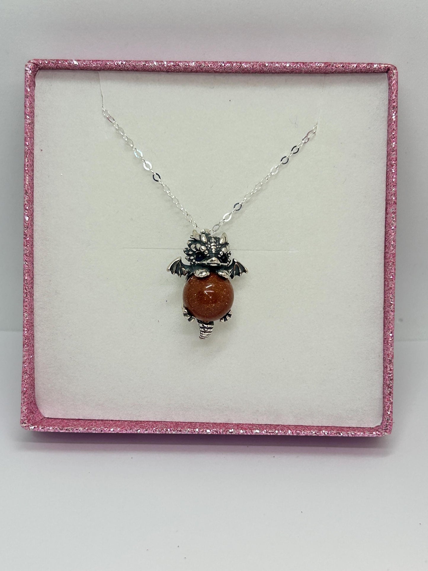 Celtic Dragon Jewellery sterling silver baby dragon pendant with red sandstone sphere and blue eyes, gift boxed.