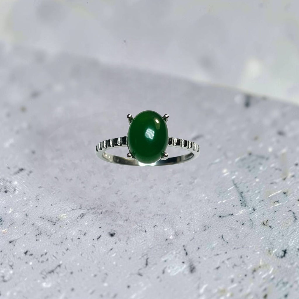 Celtic Dragon Jewellery adjustable silver ring with claw-set oval green jade gemstone and ridged band.
