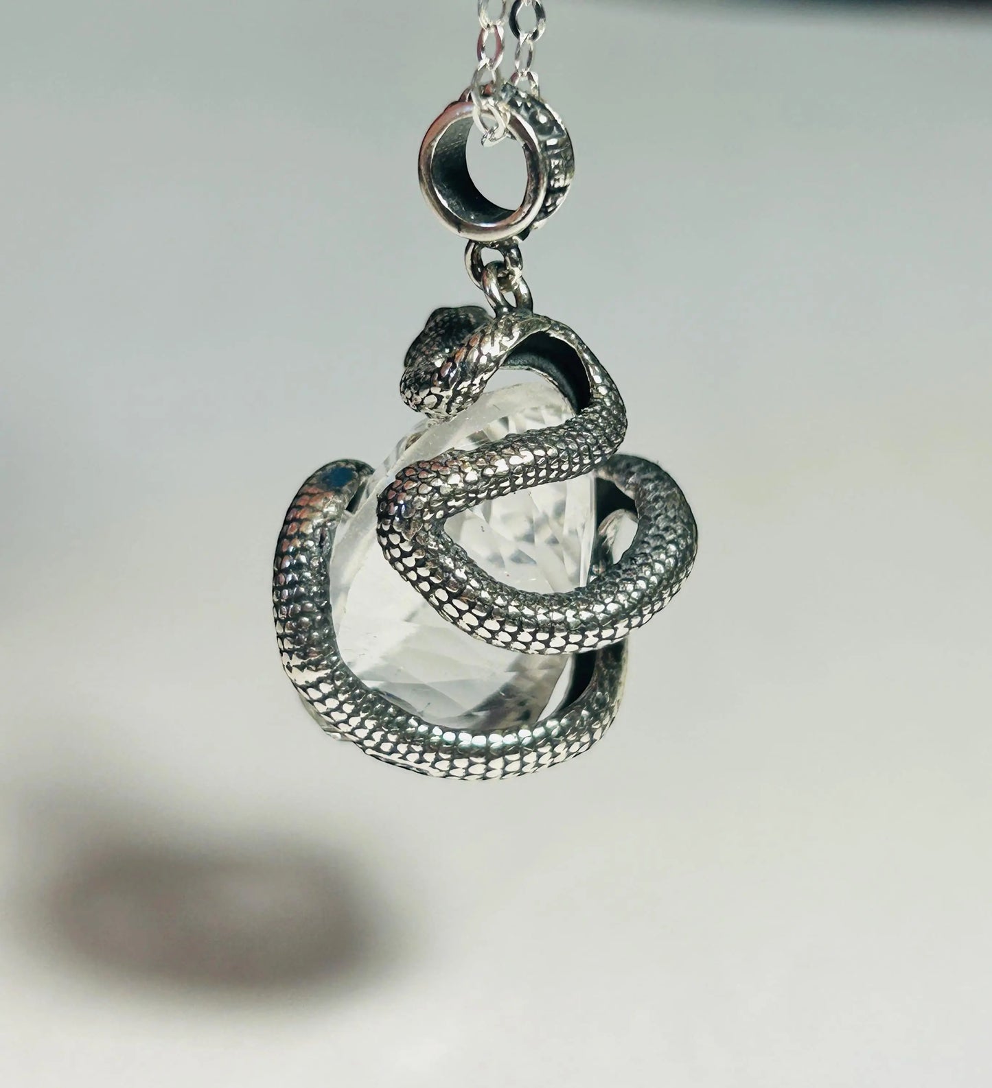 Celtic Dragon Jewellery Sterling Silver snake pendant coiled around a clear quartz gemstone. Gift boxed.